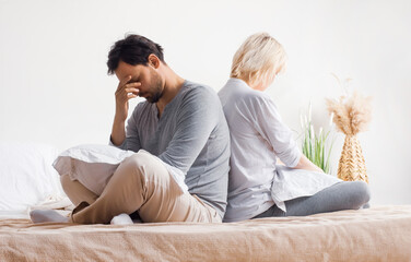 Unhappy sad couple, family, bearded man, woman, husband, wife sit at bed, turned away back to back from each other. Unlove crisis, sexual problem issues, relationship conflict, divorce - concept image - obrazy, fototapety, plakaty
