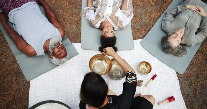 Sound, meditation and people with Tibetan singing bowl for indigenous spiritual healing in holistic practice. Soul, music and relax outdoor to calm vibration of metal instrument in nature from above