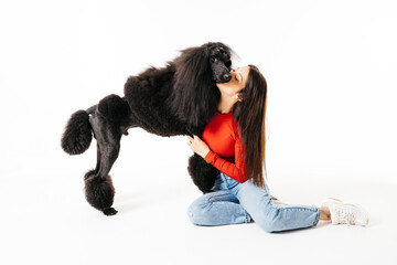 Woman Sitting on Floor Kissing Poodle Dog