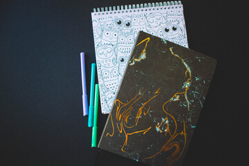 Felt pen and notepads on a black paper background. Copy space