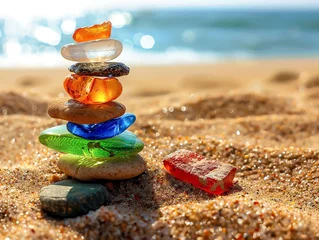 Foto auf Alu-Dibond Pile of transparent colored stones on the beach at the background the blurred sea © alla.naumenco