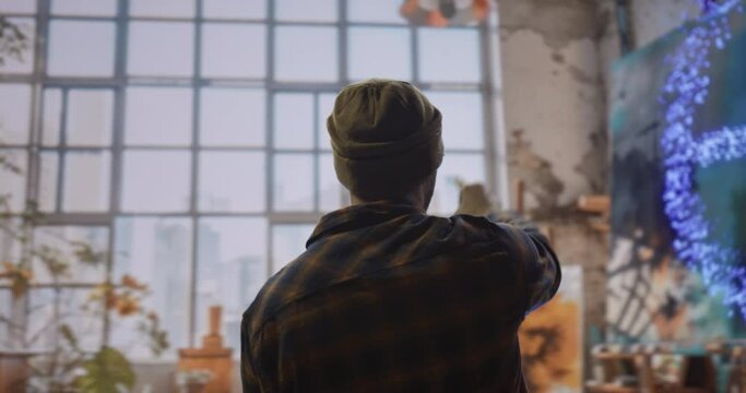 A Man Standing In Front Of A Painting On A Easel Abandoned Warehouse Interior Video Art Painting