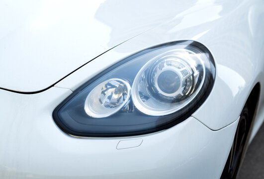 Kyiv, Ukraine - 11.04 2024. close up of headlight of luxury white Porsche. Headlight of the machine.