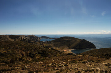 Landscape on Isla Del Sol in Bolivia composed of terraces, lake Iticaca and small port in the...