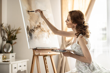 Beautiful female painter enjoying while painting in home art studio. Woman Artist Works on Abstract acrylic painting in the art studio - 782160330