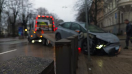 Blurred image shows car accident on city street involving vehicle and tire