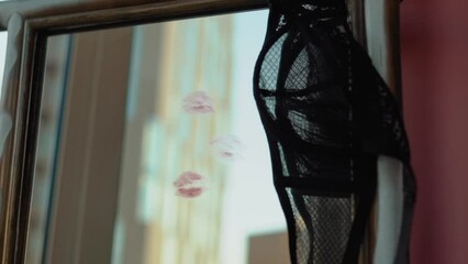 sexy girl writes a love message on the mirror and glass with red lipstick. The phrase I love you on the first date of a man and a woman. Erotic and romantic atmosphere with hearts and black lace bra