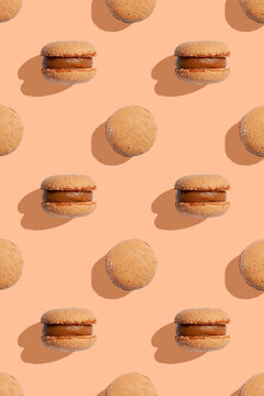 Beige color macaroons cookies on a peach fuzz background