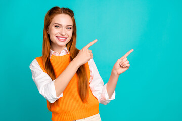 Photo portrait of pretty young girl point empty space wear trendy orange knitwear outfit isolated on cyan color background