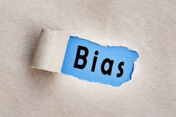 Bias text on brown paper with torn hole and rolled edge. - obrazy, fototapety, plakaty
