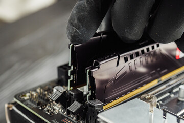 a specialist installs DDR-5 memory on the latest motherboard