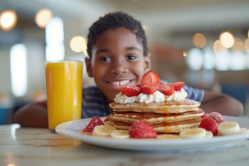 n African American boy with a joyful smile having pancakes and a glass of orange juice. - obrazy, fototapety, plakaty