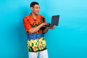 Photo of funky positive guy dressed print shirt communicating modern device isolated blue color...