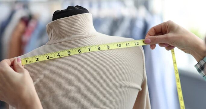 Female tailor takes measurements on mannequin. Atelier for repair and tailoring of stylish clothes concept