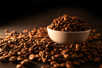Coffee beans on warm light with white cup
