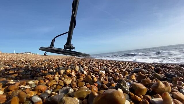 slow motion metal detecting beach swing of metal detector coil  - video stock footage