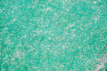Fototapeta na wymiar Weathered aged cracked plastic surface closeup as green grunge background