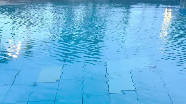 Water flow and stream circulating in a swimming pool or a large pond of water. Seen here is the water ripple and small wave seen moving in motion on the water pool surfaces.