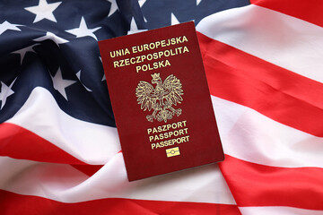 Poland passport on United States national flag background close up. Tourism and diplomacy concept