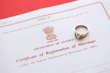 Indian Certificate of registration of marriage blank document and wedding ring on table close up