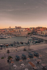 Vista panoramica sul lungomare e porto turistico di Bisceglie in Puglia al tramonto.