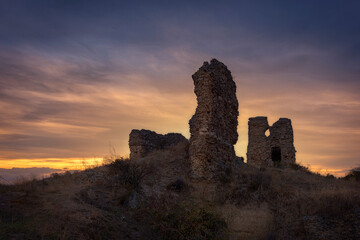 Ruins of the medieval castle of Saldaña in Palencia at sunset with a cloudy sky and warm colors