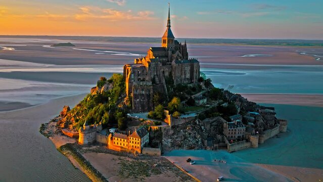 Aerial dramatic sunset over iconic French castle in Europe. Mont Saint-Michel on a tidal island in Normandy, France.