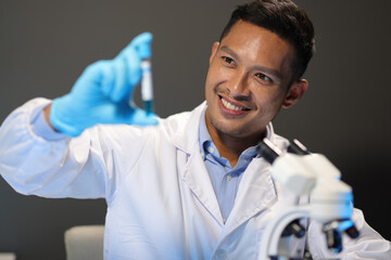 Scientists test the chemical reactions of the colored liquid solution and test biological fluids in...