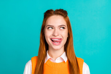 Photo portrait of pretty young girl lick teeth look empty space wear trendy orange knitwear outfit...