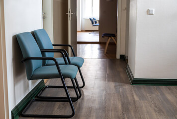 Zwei Stühle in einem Wartezimmer beim Amt