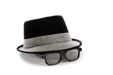 A mans black fedora hat with a white band with white rim glasses in a funny arrangement isolated on...