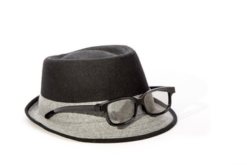A mans black fedora hat with a white band with white rim glasses in a funny arrangement isolated on...