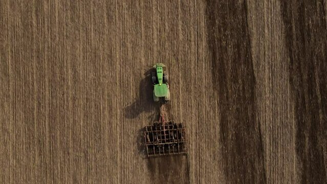 Top view or aerial drone view on tractor plows the agricultural field. Agricultural concept. Full HD resolution drone video of tractor and field. Sowing.