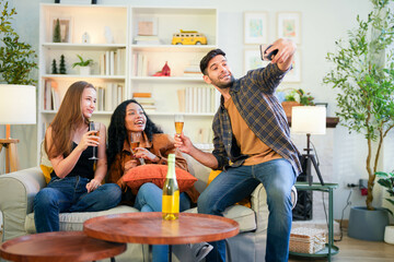 Friends capturing a joyful selfie moment with champagne, sharing laughter in a vibrant, homey...