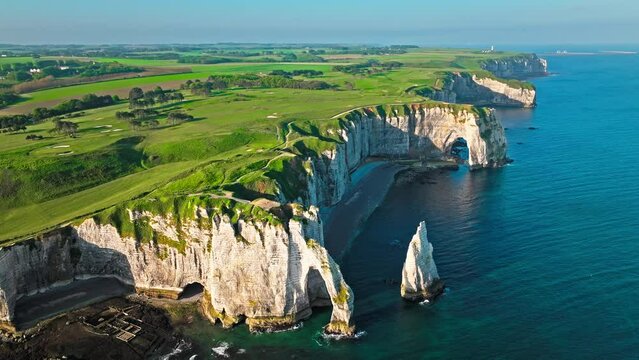 Aerial view of Towering white cliff featuring natural arch by the sea in France. Scenic view of Falaise d'Aval in Etretat, France. Rock formation by the water edge, scenic point tourist attraction.