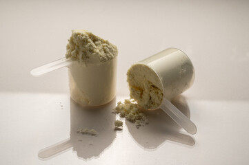 Vanilla protein powder in scoops. Food supplement, nutrition 