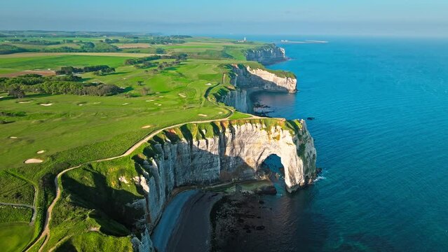 Aerial view of Towering white cliff featuring natural arch by the sea in France. Scenic view of Falaise d'Aval in Etretat, France. Rock formation by the water edge, scenic point tourist attraction.