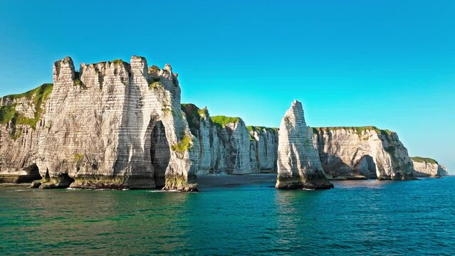 Aerial view of Towering white cliff featuring natural arch by the sea in France. Scenic view of Falaise d'Aval in Etretat, France. Rock formation by the water edge, scenic point tourist attraction.