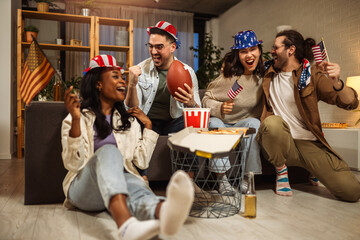 Multiracial group of friends watching rugby with American flags.