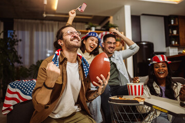 Multiracial group of friends watching rugby with American flags.