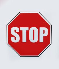 A red stop sign on a white background in close-up...