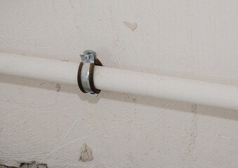 Close up on metal pipe holder in the wall