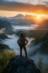 Obraz premium A traveler capturing the beauty of a majestic sunrise over a misty mountain range. A traveler on a highland admires the sunset over the mountain range