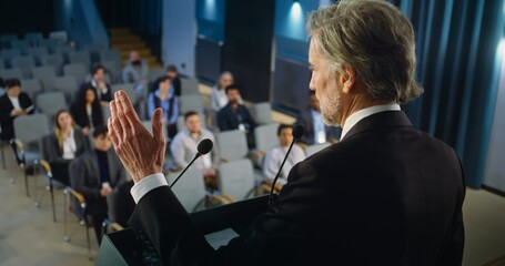 Back view of politician or activist pronouncing speech during press campaign in the conference...