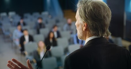 Back view of politician or activist pronouncing speech during press campaign in the conference...