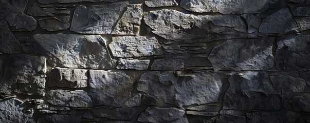 Textured gray stone wall in shadow and light