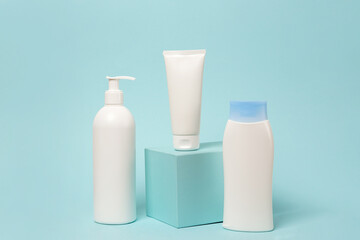 Three white cosmetic product mockups on blue background