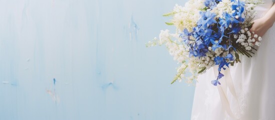 Bride holding vertical bouquet with blue flowers
