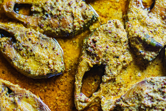 Sorshe ilish or hilsa fish curry cooked with mustard seeds. It is a very famous Bengali dish. Pieces of fish are seen in rich yellow gravy. This is traditional delicacy in Bengali culture.