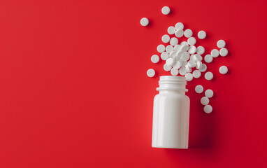 White pill bottle tipped over with pills scattered, red color background, top view - pill bottle, healthcare medication spill, pharmaceuticals medical supplies.